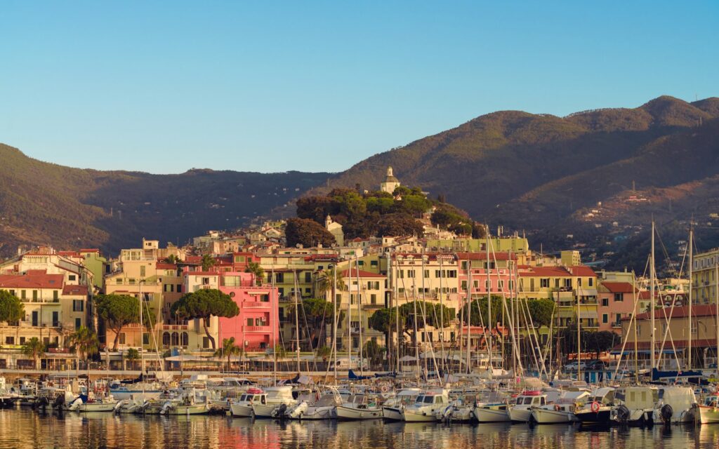 a harbor filled with lots of boats next to a mountain