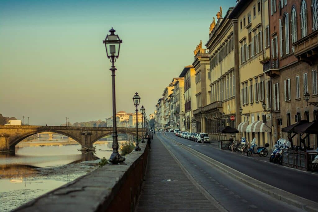 eine Reihe von Gebäuden entlang eines Flusses mit einer Brücke im Hintergrund